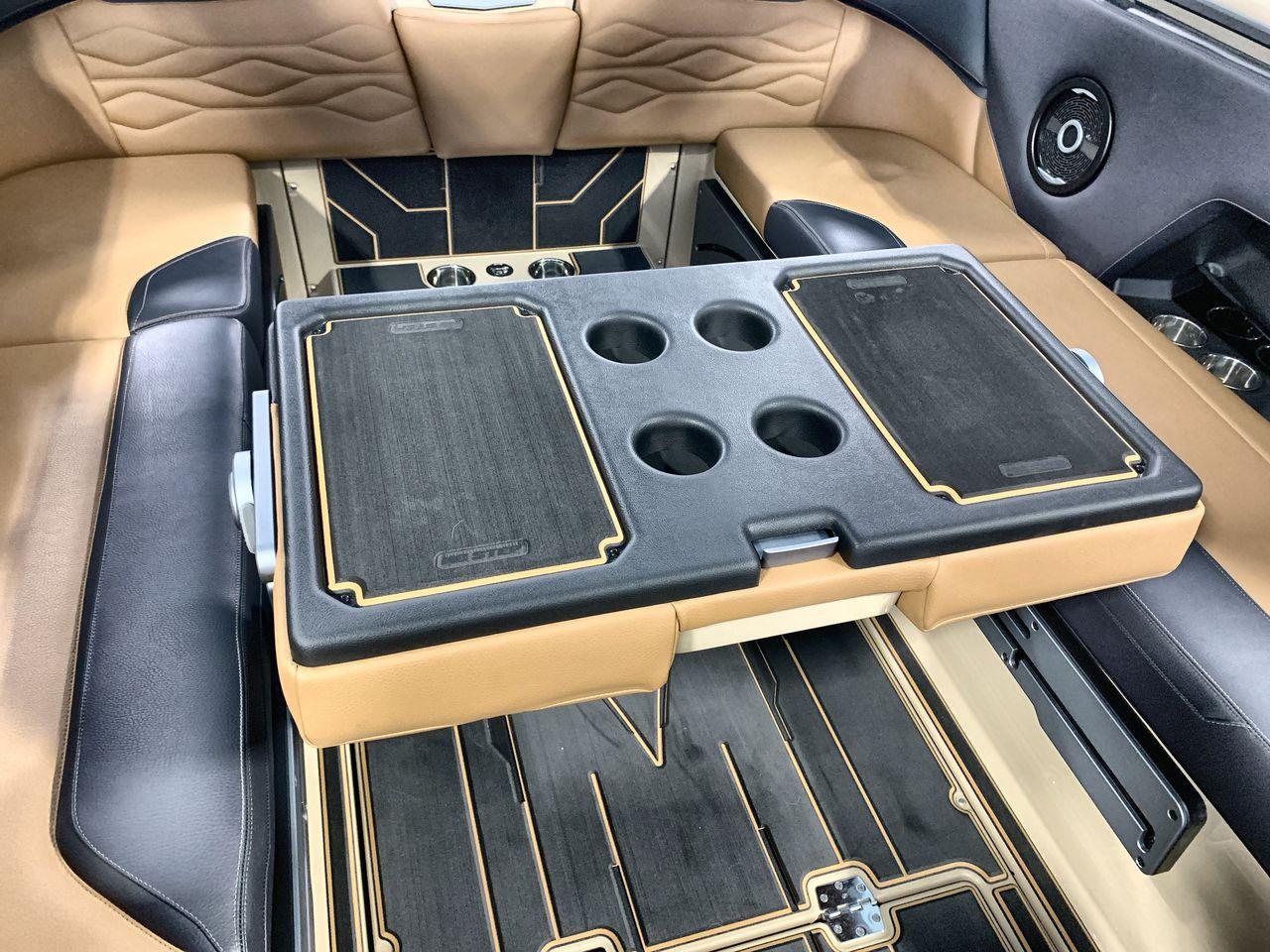 Slide: The Image of 2025 Supra SE interior with luxurious seating and multifunctional table featuring cup holders. - 22