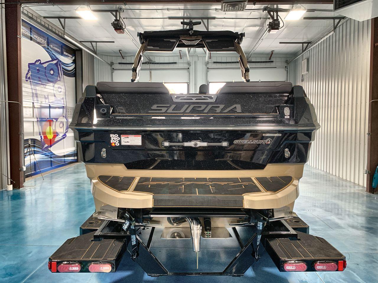 Slide: The Image of 2025 Supra SE boat in a garage, rear view showcasing sleek design and features. - 3