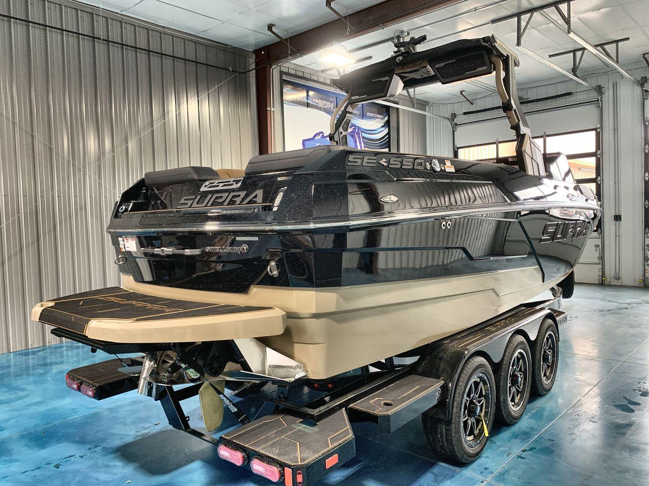 Slide: The Image of 2025 Supra SE boat in a garage, showcasing sleek design and triple-axle trailer. - 4