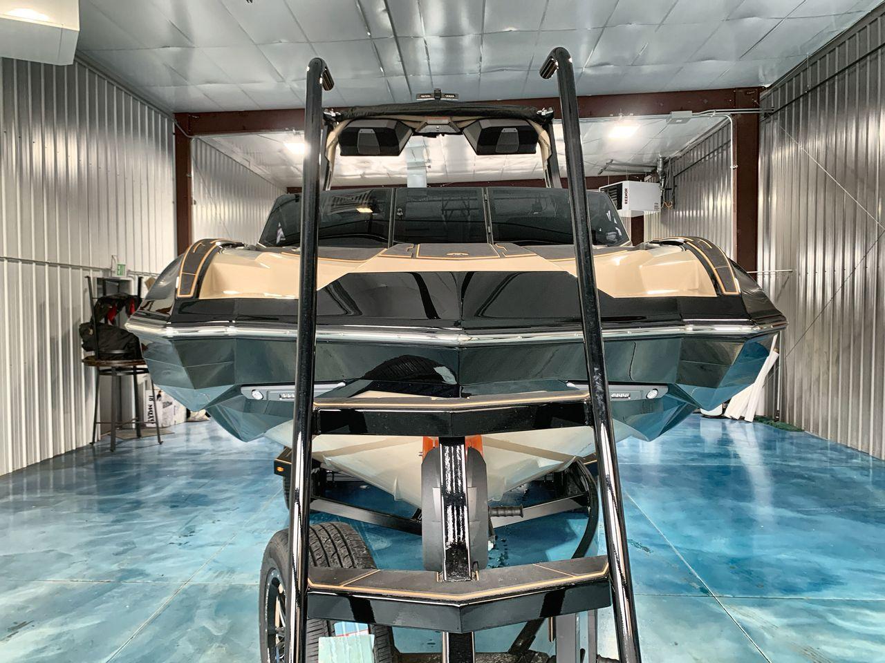 Slide: The Image of 2025 Supra SE boat in storage, viewed from the front with a ladder in foreground. - 7