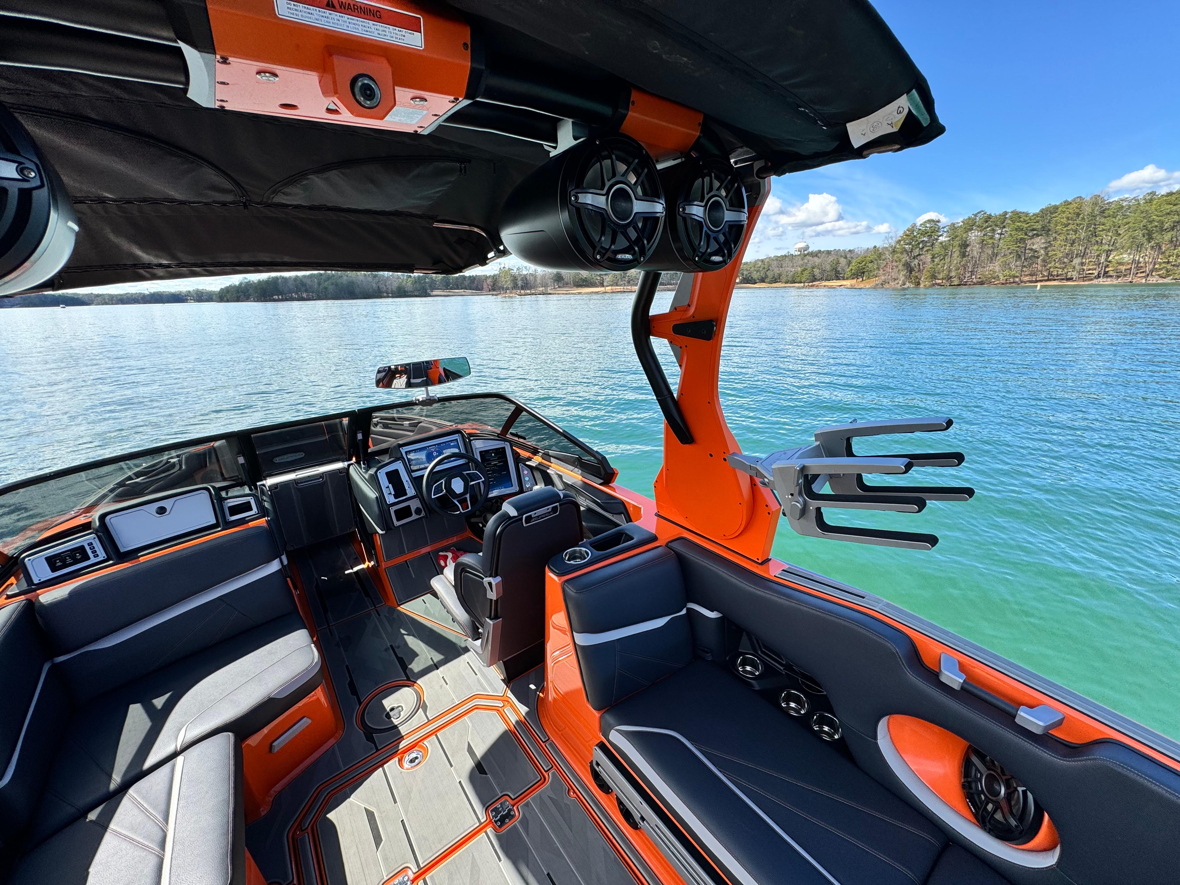 Slide: The Image of 2022 Supra SL 550 boat interior with orange accents on a serene lake. - 6