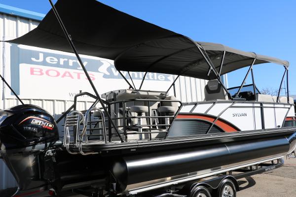 Slide: The Image of 2025 Sylvan L3 DLZ Bar Tri-Toon boat with canopy, displayed at dealership. - 4