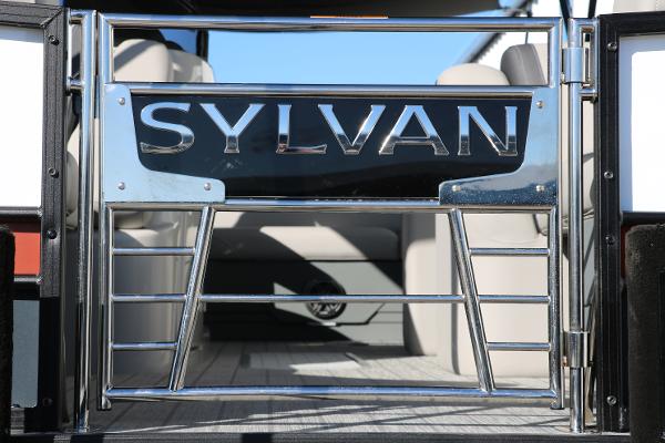 Slide: The Image of 2025 Sylvan L3 DLZ Bar Tri-Toon boat gate with chrome finish and seating area. - 8