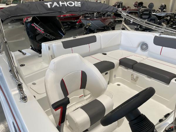 Slide: The Image of 2023 Tahoe 1950 boat interior with white and gray seating, steering wheel, and motor. - 10