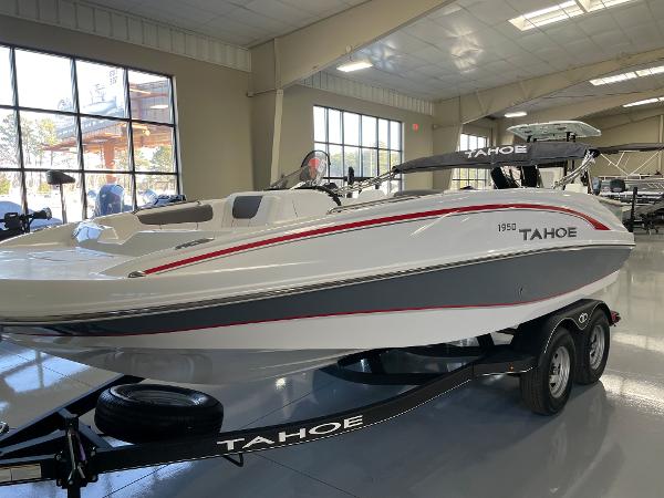 Slide: The Image of 2023 Tahoe 1950 boat on trailer in indoor showroom. - 2