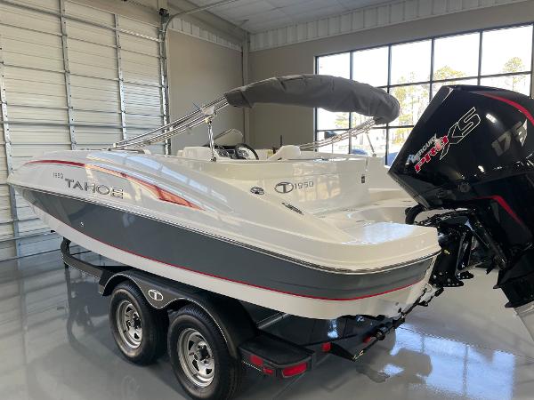 Slide: The Image of 2023 Tahoe 1950 boat on trailer in showroom with outboard motor. - 3