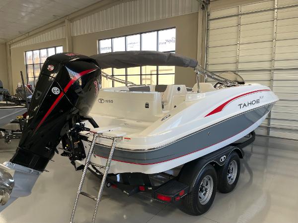 Slide: The Image of 2023 Tahoe 1950 boat in showroom, featuring a powerful outboard motor. - 4