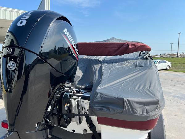Slide: The Image of 2023 Tahoe 200 S boat with Mercury outboard motor, covered and parked outdoors. - 12