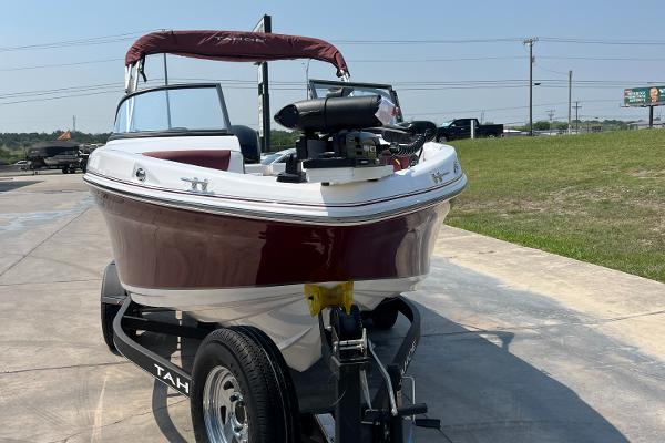 Slide: The Image of 2023 Tahoe 200 S boat on trailer, red and white, parked outdoors. - 2