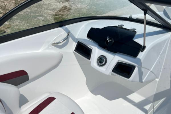 Slide: The Image of 2023 Tahoe 200 S boat interior dashboard with white and red seating. - 7