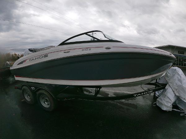 Slide: The Image of 2024 Tahoe 210 S boat on trailer under cloudy sky. - 0
