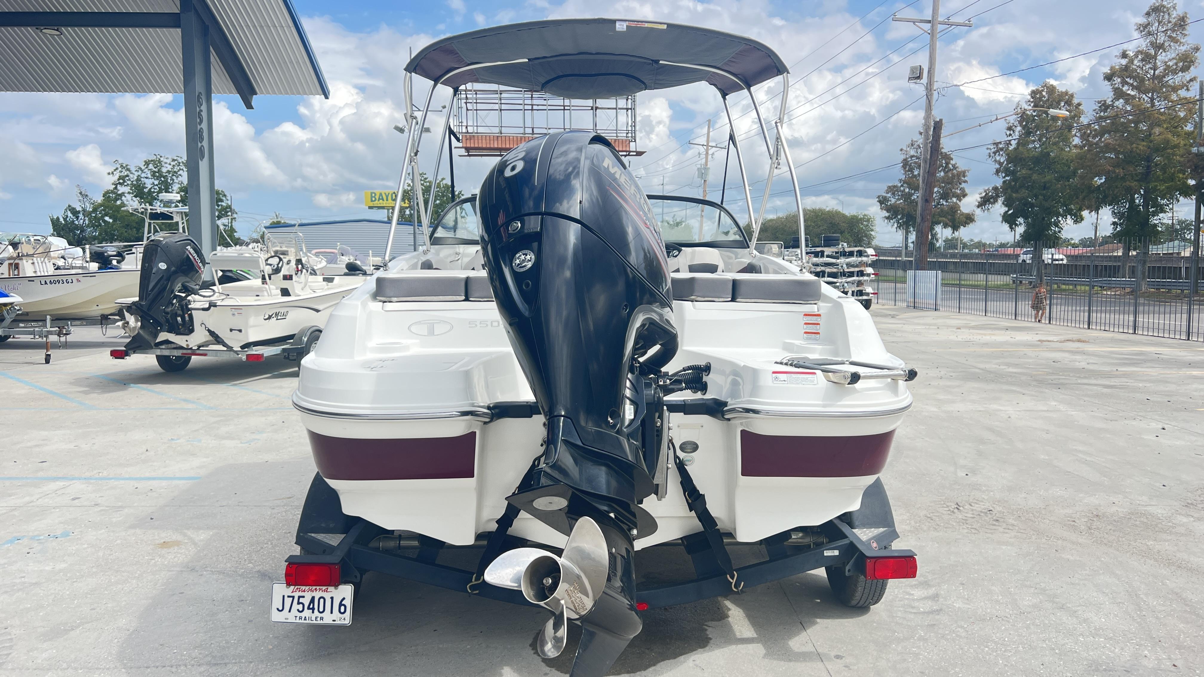 Slide: The Image of 2018 Tahoe 550 TS boat on trailer, rear view with outboard motor, parked outdoors. - 4