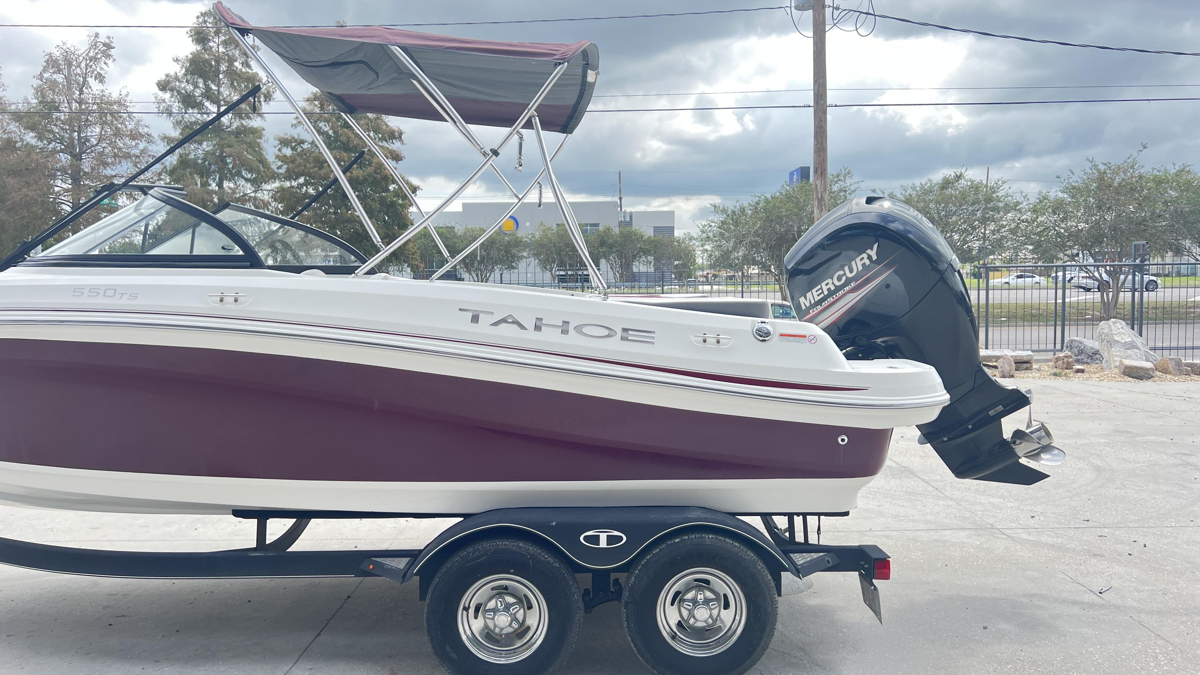 Slide: The Image of 2018 Tahoe 550 TS boat with Mercury outboard motor on trailer, parked outdoors. - 6