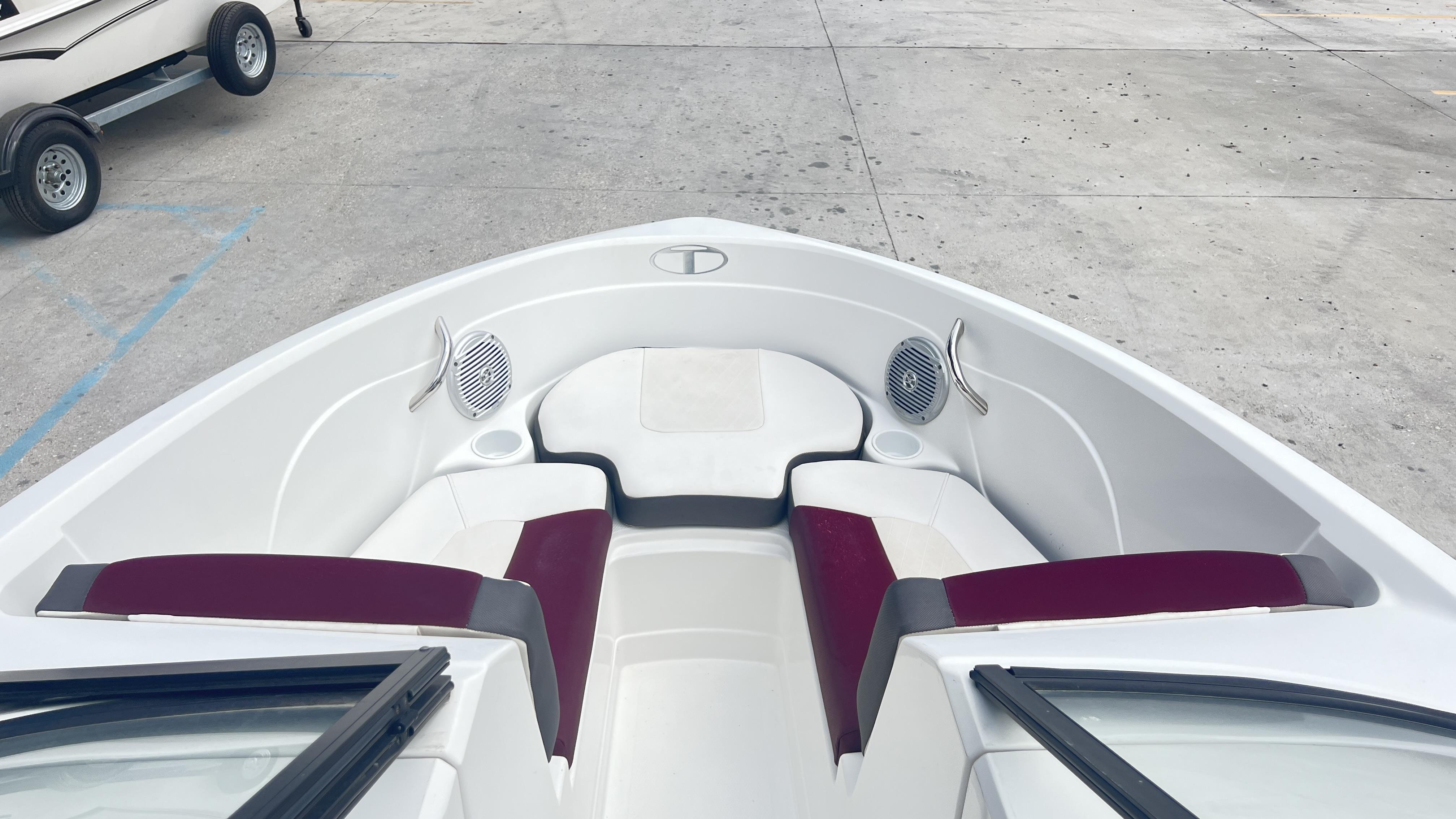 Slide: The Image of 2018 Tahoe 550 TS boat interior with red and white seating, cup holders, and speakers. - 9