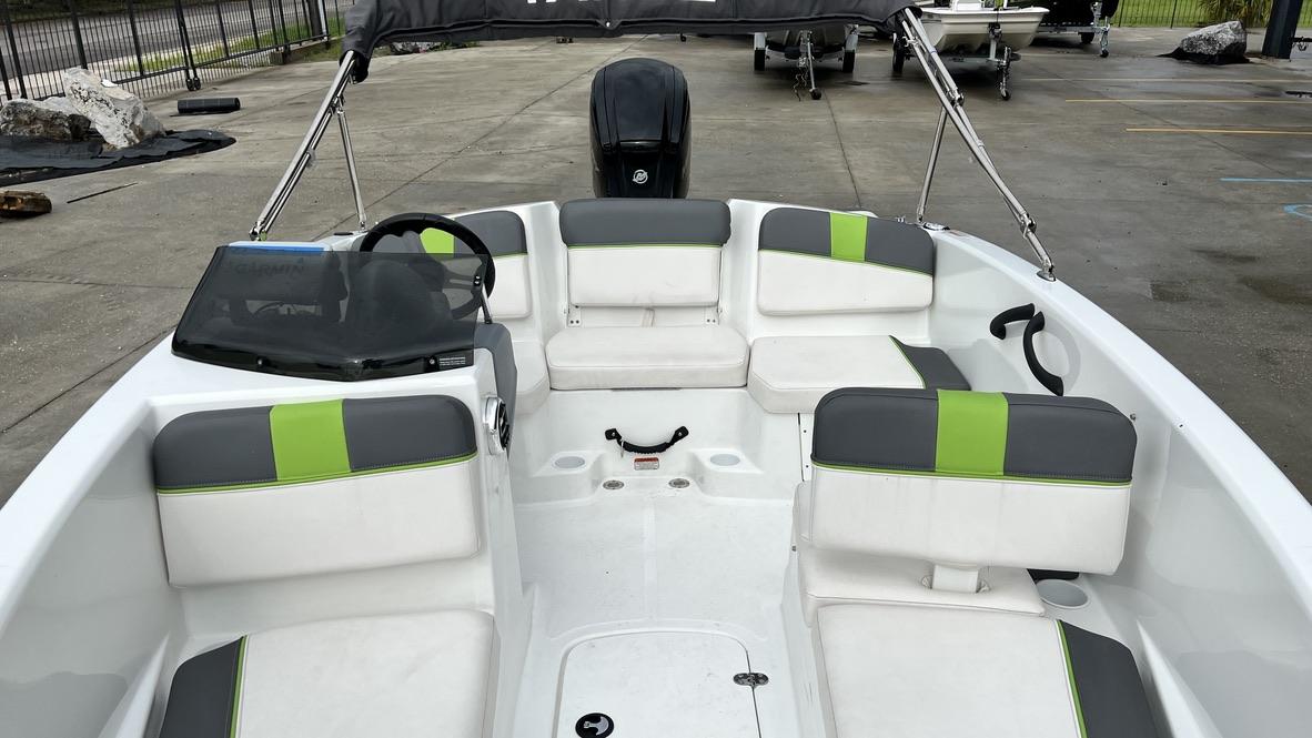 Slide: The Image of 2021 Tahoe T16 boat interior with gray and green seating, steering wheel, and windshield. - 10