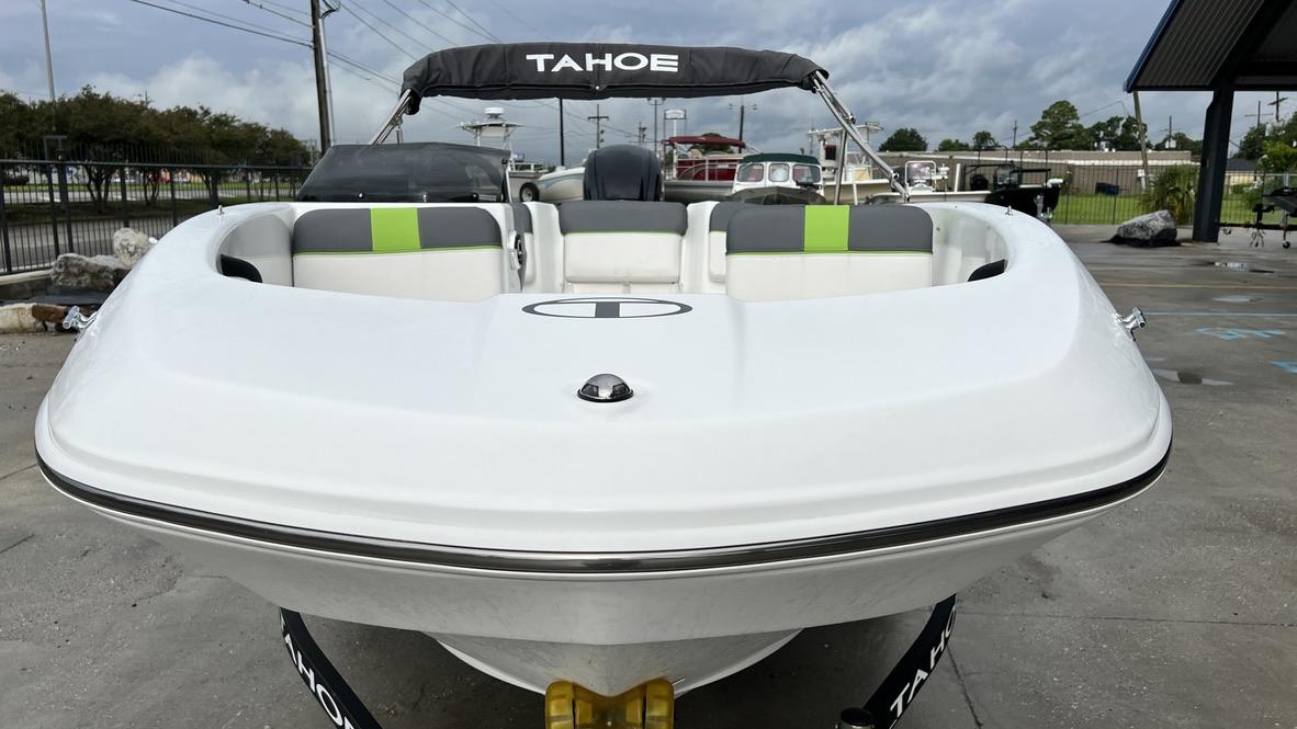 Slide: The Image of 2021 Tahoe T16 boat with white hull and green-accented seats, docked outdoors. - 3