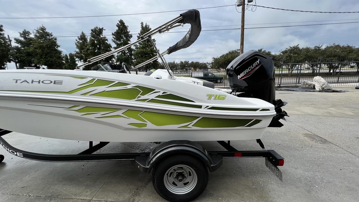 Slide: The Image of 2021 Tahoe T16 boat with green graphics and Mercury outboard motor on trailer. - 4