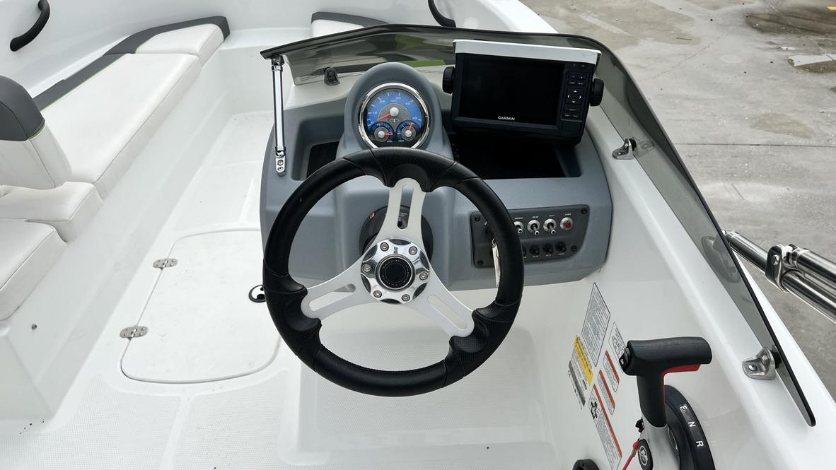 Slide: The Image of 2021 Tahoe T16 boat dashboard with steering wheel, control panel, and Garmin display. - 7