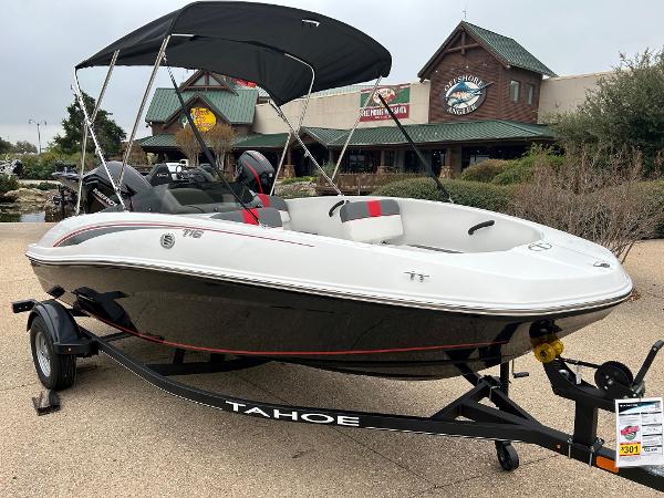 Slide: The Image of 2024 Tahoe T16 boat on trailer with canopy in front of a store. - 0