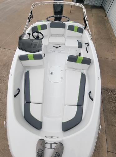Slide: The Image of 2024 Tahoe T16 boat with white and gray seating, green accents, and a steering console. - 3