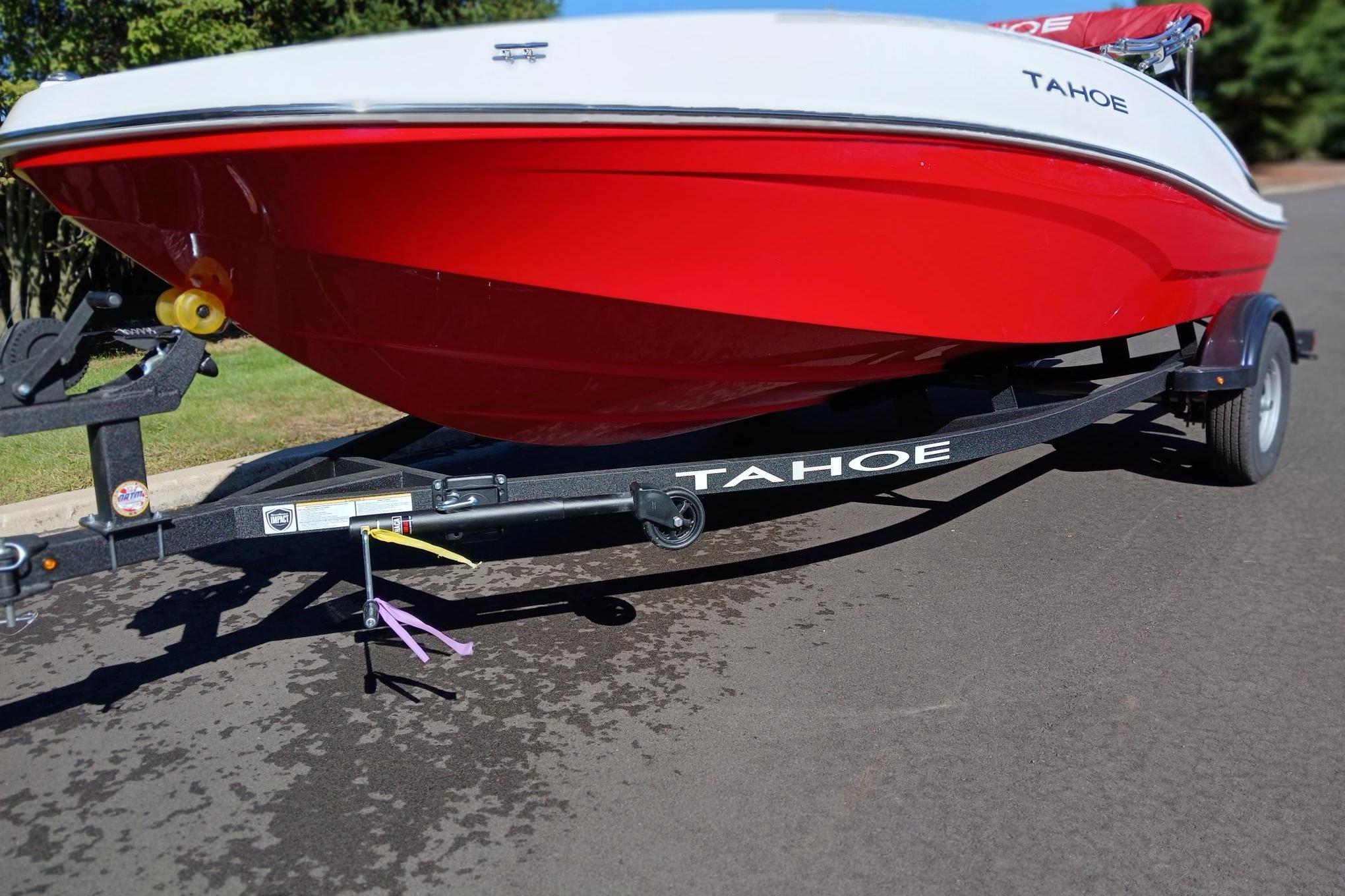 Slide: The Image of 2026 Tahoe T16 boat on trailer, red and white design, parked on pavement. - 1