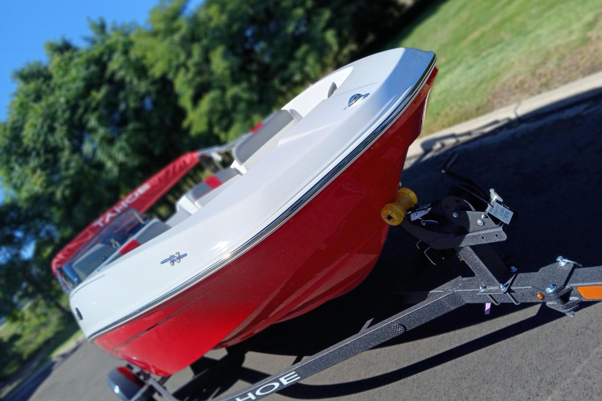 Slide: The Image of 2026 Tahoe T16 boat on trailer, red and white design, parked outdoors. - 3