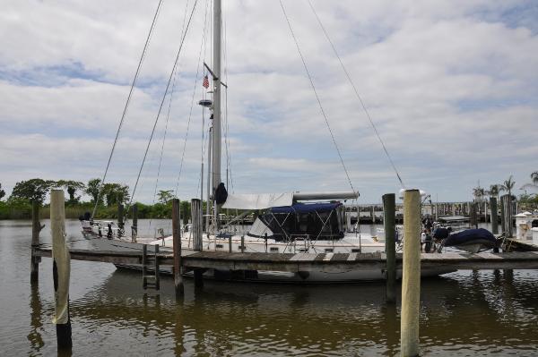 Slide: The Image of 1988 Tayana 52 sailboat docked at a marina on a cloudy day. - 0