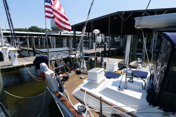 Slide: The Image of 1988 Tayana 52 sailboat docked at marina with American flag. - 11