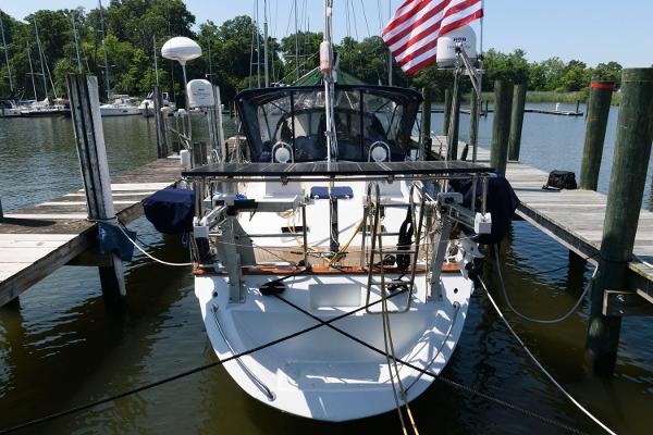Slide: The Image of 1988 Tayana 52 sailboat docked at marina with American flag. - 12