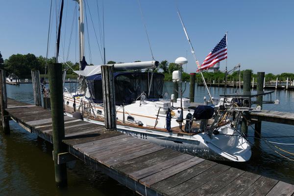 Slide: The Image of 1988 Tayana 52 sailboat docked with American flag. - 17