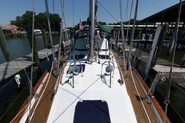 Slide: The Image of 1988 Tayana 52 sailboat docked at a marina, view of the deck and rigging. - 2