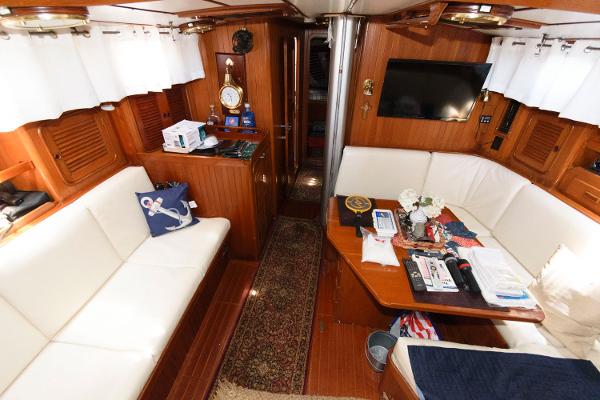 Slide: The Image of Interior of 1988 Tayana 52 yacht with white seating, wooden finishes, and a mounted TV. - 22