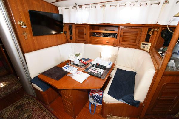 Slide: The Image of Interior of 1988 Tayana 52 sailboat with cozy dining area and wooden furnishings. - 23