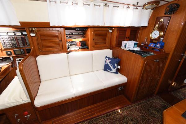 Slide: The Image of Interior of 1988 Tayana 52 yacht with white cushioned seating and nautical decor. - 24