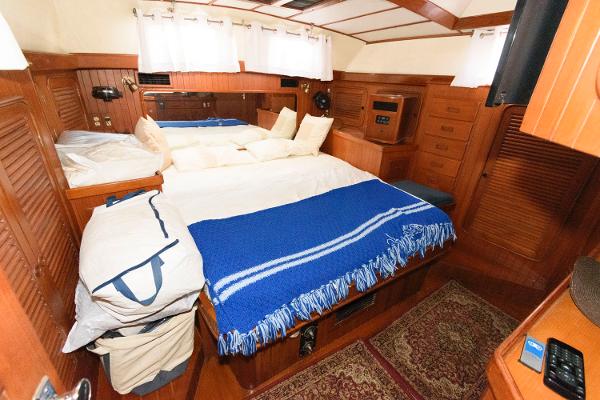 Slide: The Image of Cozy cabin interior of 1988 Tayana 52 yacht with wooden furnishings and blue blanket. - 27