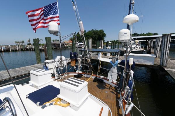 Slide: The Image of 1988 Tayana 52 sailboat docked at a marina with American flag. - 3