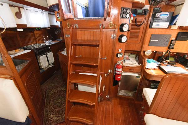 Slide: The Image of Interior of 1988 Tayana 52 sailboat with wooden stairs, galley, and navigation station. - 33