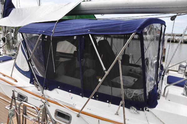 Slide: The Image of 1988 Tayana 52 sailboat with blue cockpit enclosure docked at marina. - 5