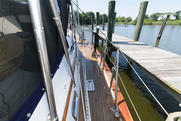 Slide: The Image of Side deck view of 1988 Tayana 52 sailboat docked at a wooden pier. - 7