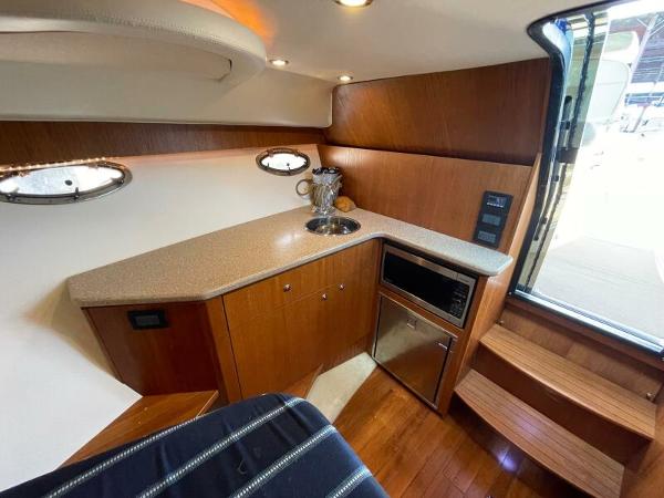 Slide: The Image of Interior of 2012 Tiara Yachts 3100 Coronet with kitchenette and wooden cabinetry. - 11