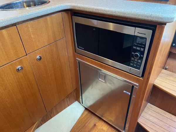 Slide: The Image of 2012 Tiara Yachts 3100 Coronet galley with microwave and compact fridge. - 12