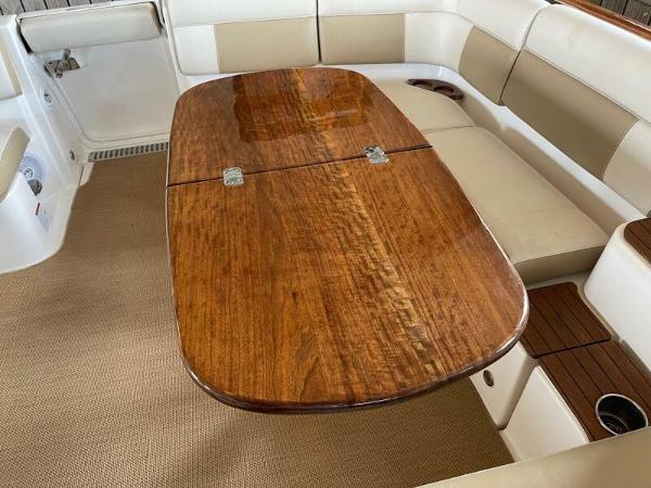 Slide: The Image of Luxurious wooden table on 2012 Tiara Yachts 3100 Coronet, surrounded by beige seating. - 14