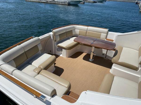 Slide: The Image of 2012 Tiara Yachts 3100 Coronet with spacious seating and wooden table on deck. - 15
