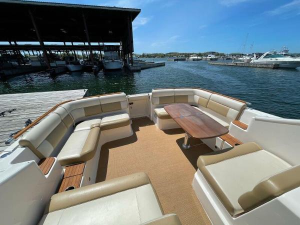 Slide: The Image of 2012 Tiara Yachts 3100 Coronet with spacious seating and table, docked by the marina. - 17