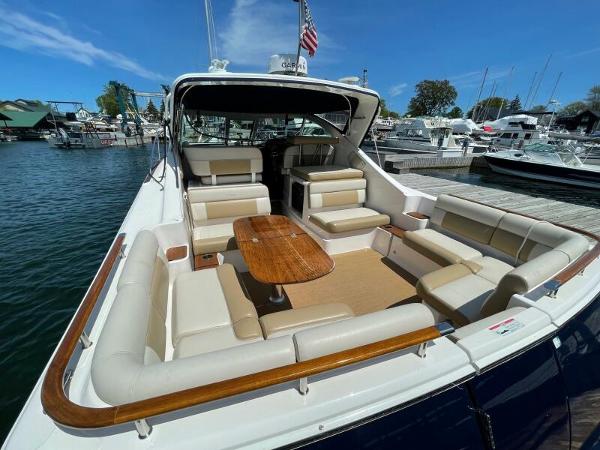 Slide: The Image of 2012 Tiara Yachts 3100 Coronet with spacious seating and wooden table, docked at marina. - 4