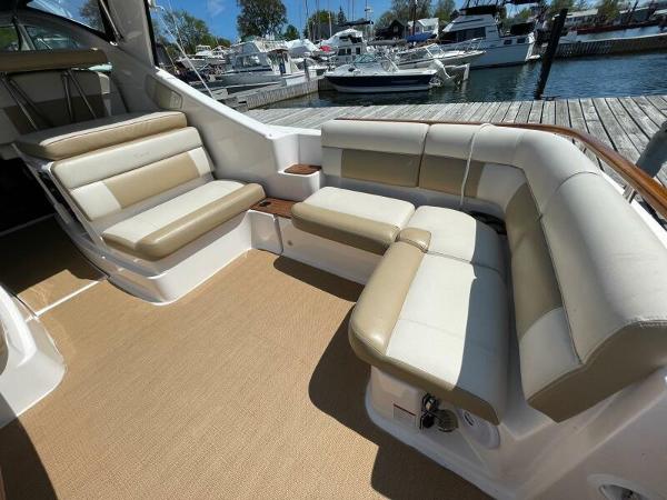 Slide: The Image of 2012 Tiara Yachts 3100 Coronet interior with beige seating, docked at marina. - 5