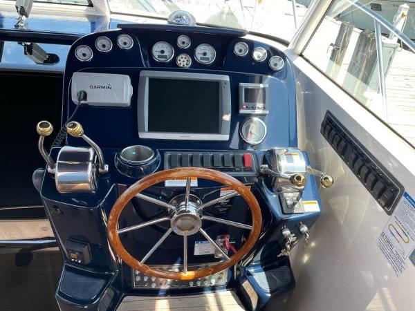 Slide: The Image of Helm of 2012 Tiara Yachts 3100 Coronet with wooden steering wheel and navigation controls. - 6