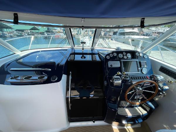 Slide: The Image of 2012 Tiara Yachts 3100 Coronet helm with modern controls and wooden steering wheel. - 9