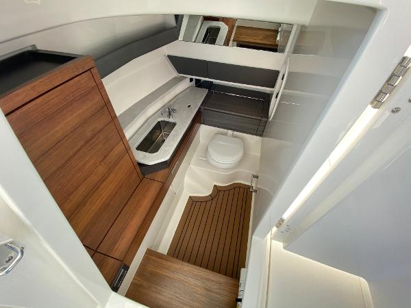 Slide: The Image of 2021 Tiara Yachts 34 LX interior with modern bathroom and wooden accents. - 24