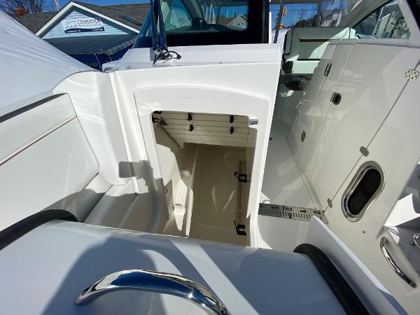 Slide: The Image of 2021 Tiara Yachts 34 LX interior, showcasing sleek white design and storage compartment. - 32